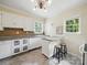 Bright kitchen with a chandelier, light counter tops, white cabinets, stainless steel dishwasher and island with stools at 308 W Monroe St, Salisbury, NC 28144