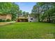 A well manicured back yard features a newly renovated home with a large wood deck at 3326 Winterfield Pl, Charlotte, NC 28205