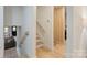 Bright hallway featuring hardwood floors, a staircase, and a modern wood slat wall accent at 3326 Winterfield Pl, Charlotte, NC 28205