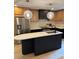 An open kitchen features stainless steel appliances, a black island, and stylish pendant lighting at 3326 Winterfield Pl, Charlotte, NC 28205