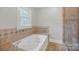 Luxurious bathroom with a soaking tub, tiled surround, and a separate glass shower at 361 5Th Nw St, Hickory, NC 28601