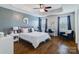 Comfortable bedroom featuring hardwood floors, tray ceiling, windows, and a decorative chair at 4060 Zilker Park Dr, Charlotte, NC 28217