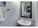 A clean, updated powder room with a modern sink, faucet, framed mirror, and stylish decor at 4060 Zilker Park Dr, Charlotte, NC 28217