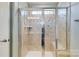 Tiled shower with glass doors, a bench, and modern fixtures at 4060 Zilker Park Dr, Charlotte, NC 28217