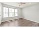 Light-filled bedroom with hardwood floors, ceiling fan, and ample natural light from three windows at 420 E 16Th St, Charlotte, NC 28206