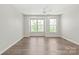 Spacious bedroom with hardwood floors, a ceiling fan, and ample natural light from large windows at 420 E 16Th St, Charlotte, NC 28206
