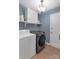 Clean laundry room with front-load washer, dryer, shelves, and storage at 4407 Beauvista Dr, Charlotte, NC 28269