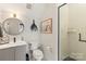 Modern bathroom featuring a sleek vanity, round mirror, and a glass-enclosed shower with stylish vertical tiling at 4520 Radler Ct, Charlotte, NC 28217