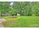 Expansive backyard featuring a fire pit, seating, storage shed, and mature trees at 4633 Cringle Ct, Charlotte, NC 28226