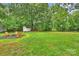 Lush backyard with a fire pit, seating, mature trees, and a storage shed at 4633 Cringle Ct, Charlotte, NC 28226