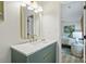 Bathroom vanity with carrara countertop, gold fixtures, green cabinets and modern lighting at 4633 Cringle Ct, Charlotte, NC 28226