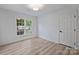 Bright bedroom with hardwood floors and white walls showcasing a large window and natural light at 4633 Cringle Ct, Charlotte, NC 28226