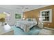 Bright bedroom featuring a wood accent wall, ceiling fan, and large window with natural light at 4633 Cringle Ct, Charlotte, NC 28226