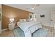 Bright bedroom featuring a wood accent wall, ceiling fan, and large window with natural light at 4633 Cringle Ct, Charlotte, NC 28226