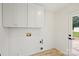 Bright laundry room featuring white cabinets, hookups, and vinyl flooring at 4633 Cringle Ct, Charlotte, NC 28226