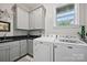 Functional laundry room with modern appliances, gray cabinets, sink, and a window for natural light at 5118 Waldron Meadow Dr, Charlotte, NC 28226