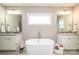 The primary bathroom features dual sinks, a free standing tub, and plenty of natural light at 517 E Main St, Rock Hill, SC 29730