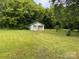 Grassy backyard featuring a detached garage, providing ample outdoor space at 6561 Weldon Nw Cir, Concord, NC 28027