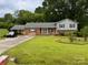 Classic two-story home with a well-kept lawn, complemented by mature trees and convenient covered parking at 6561 Weldon Nw Cir, Concord, NC 28027