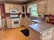 Efficient kitchen layout featuring neutral-toned cabinets, essential appliances, and durable flooring, ready for personal updates at 6561 Weldon Nw Cir, Concord, NC 28027