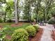Well-maintained backyard with a patio, seating area, manicured landscaping, and lush greenery at 6941 Queensberry Dr, Charlotte, NC 28226