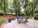 Spacious backyard featuring a patio with outdoor dining and seating, surrounded by mature trees at 6941 Queensberry Dr, Charlotte, NC 28226