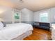 Bright bedroom features hardwood floors, neutral paint, and natural light from the two windows at 6941 Queensberry Dr, Charlotte, NC 28226