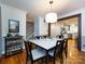 Elegant dining room with modern lighting, hardwood floors, bar area, and open view to the kitchen at 6941 Queensberry Dr, Charlotte, NC 28226