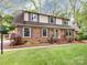 Charming two-story brick home with blue shutters and manicured lawn offering timeless appeal at 6941 Queensberry Dr, Charlotte, NC 28226