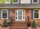 Close-up of the classic brick home's front door with sidelights and freshly landscaped walkway at 6941 Queensberry Dr, Charlotte, NC 28226