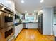 Modern kitchen featuring stainless steel appliances, white cabinets, and hardwood floors at 6941 Queensberry Dr, Charlotte, NC 28226