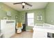 Green-painted bedroom featuring a ceiling fan, a window, and a white crib at 7024 Jane Parks Way, Charlotte, NC 28217