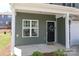 Close-up of a charming front porch with a black door and neatly kept landscaping at 7024 Jane Parks Way, Charlotte, NC 28217