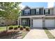 Two-story townhome showcasing an attached one-car garage and fresh landscaping at 7024 Jane Parks Way, Charlotte, NC 28217