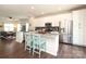 Open kitchen featuring white cabinets, stainless appliances, granite counters, island with seating, and hardwood floors at 7024 Jane Parks Way, Charlotte, NC 28217