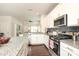 Bright kitchen features white cabinets, stainless steel appliances, granite countertops, and dark wood floors at 7024 Jane Parks Way, Charlotte, NC 28217
