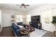 Bright living room featuring a comfortable blue sofa, hardwood floors, and large windows at 7024 Jane Parks Way, Charlotte, NC 28217