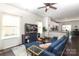 Bright living room featuring a comfortable blue sofa, hardwood floors, and large windows at 7024 Jane Parks Way, Charlotte, NC 28217
