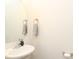Compact powder room featuring a pedestal sink, modern faucet, and neutral color palette at 7024 Jane Parks Way, Charlotte, NC 28217