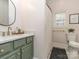 Stylish bathroom featuring a green vanity, gold fixtures, round mirror, and a shower with a patterned curtain at 705 Woburn Abbey Dr, Fort Mill, SC 29715