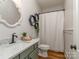 Charming bathroom with green vanity, decorative mirror, hexagon shelves, and shower with white curtain at 705 Woburn Abbey Dr, Fort Mill, SC 29715