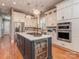 Stylish kitchen featuring white cabinetry, stainless steel appliances, and an island with a beverage cooler at 705 Woburn Abbey Dr, Fort Mill, SC 29715