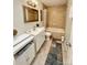 Well-lit bathroom featuring tiled walls, a vanity with storage, and a tub with shower at 7133 Tall Tree Ln, Charlotte, NC 28214