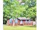 Charming brick home with a well-manicured lawn and mature trees, offering shade and curb appeal at 7133 Tall Tree Ln, Charlotte, NC 28214