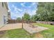This backyard features a fire pit, a concrete patio, and a grassy area with a wooden privacy fence at 720 Reigate Rd, Charlotte, NC 28262