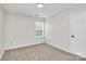 This bedroom features neutral carpet, white walls, a window with blinds, and a white door at 720 Reigate Rd, Charlotte, NC 28262