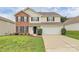 Charming two-story home featuring a brick facade, well-manicured lawn, and a two-car garage at 720 Reigate Rd, Charlotte, NC 28262