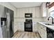 Bright kitchen features white cabinetry, modern black appliances, and hardwood flooring at 720 Reigate Rd, Charlotte, NC 28262