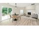 Living area with a dining table, fireplace, hardwood floors, and backyard access at 720 Reigate Rd, Charlotte, NC 28262