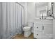 Clean, stylish bathroom featuring a shower with a curtain, white vanity, and modern fixtures at 7322 Vesper Dr, Huntersville, NC 28078
